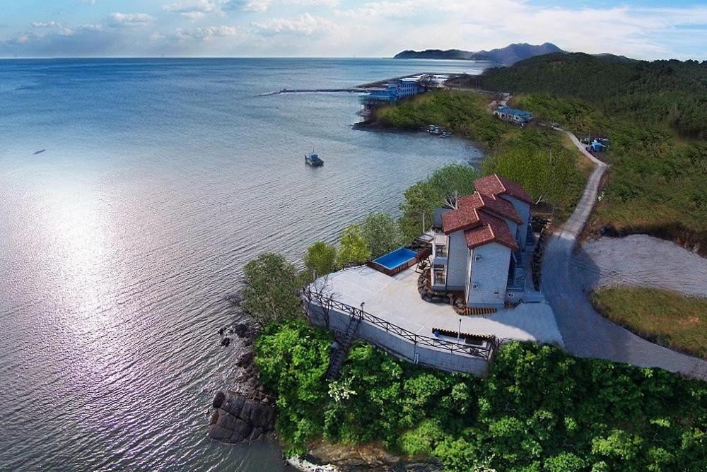 an aerial view of a house on an island in the water at Byeonsanbando Badajeonmangdae Pension in Buan
