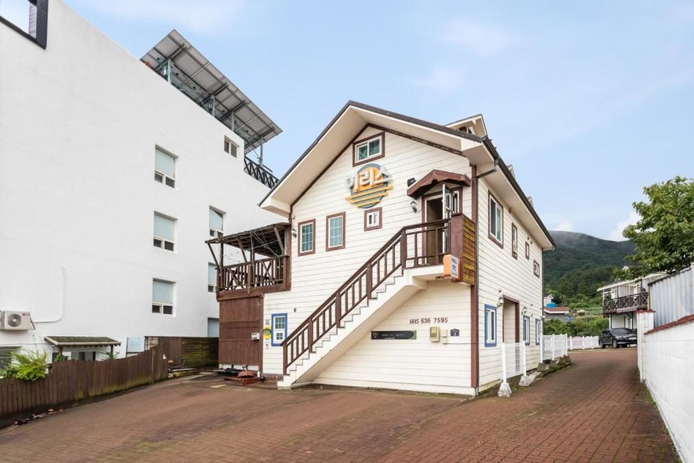 a white building with stairs on the side of it at Geoje ireece Pension in Geoje 