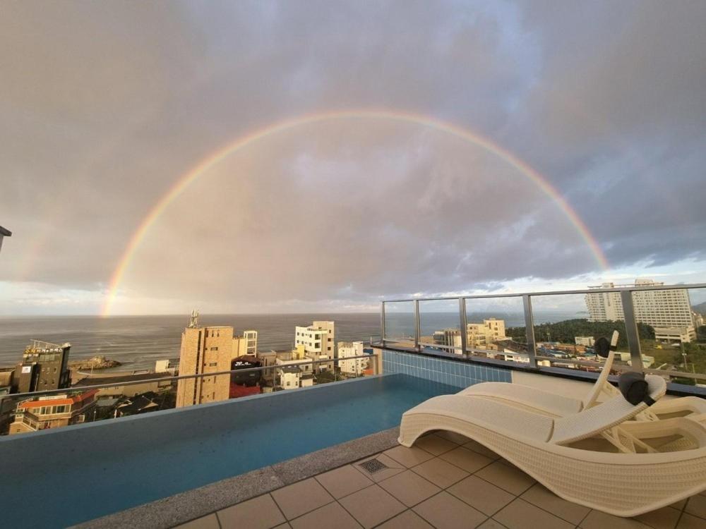 a rainbow over a balcony with a pool at Gangneung Skaria Poolvilla in Kangmun