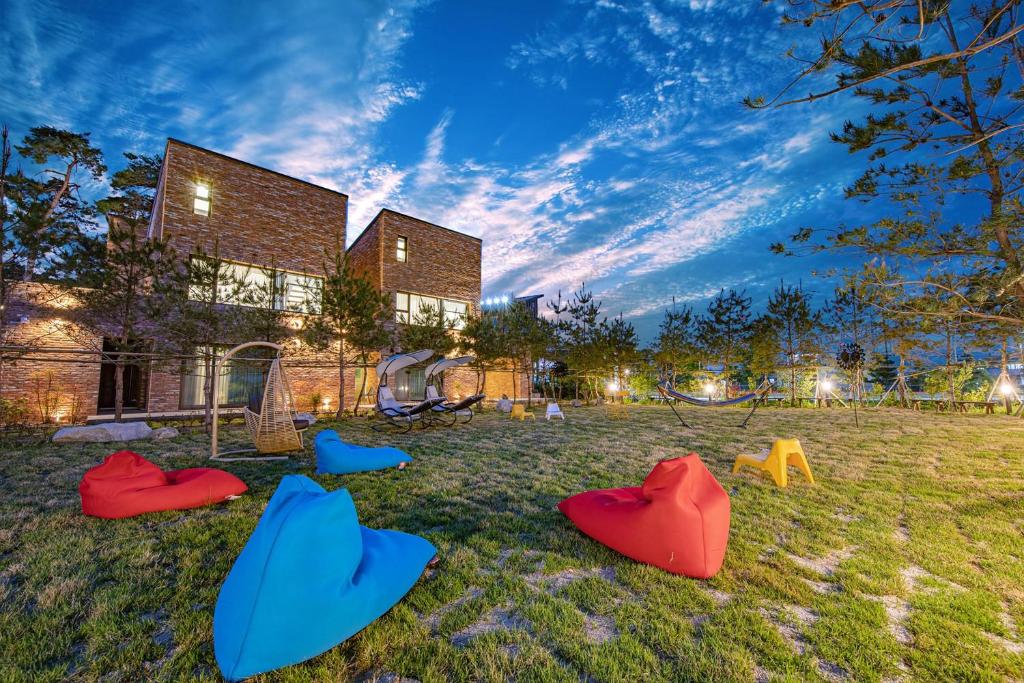 a group of chairs in the grass in front of a building at gangreung seuteieoseu in Kangmun