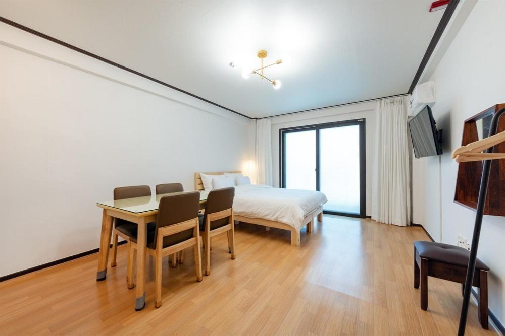 a bedroom with a bed and a desk and a table at Gangneung Marine Park Pension in Gangneung