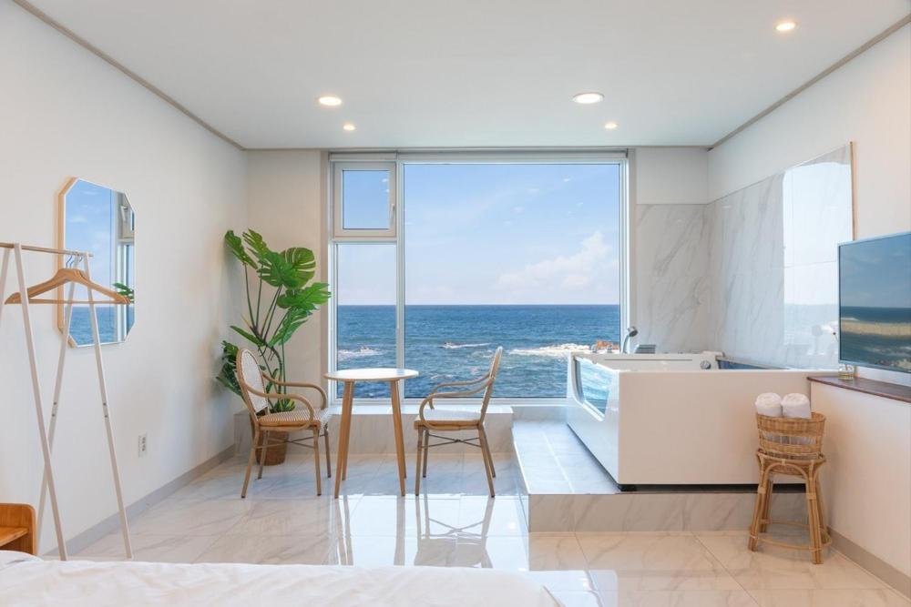 a living room with a view of the ocean at Gangneung Way Blue Spa Pension in Chumunjin