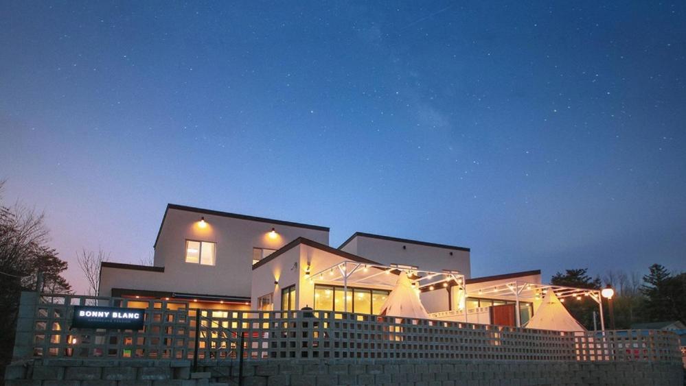 a large building with lights in front of it at night at Gangneung Boni Stay in Ŭmji-mal