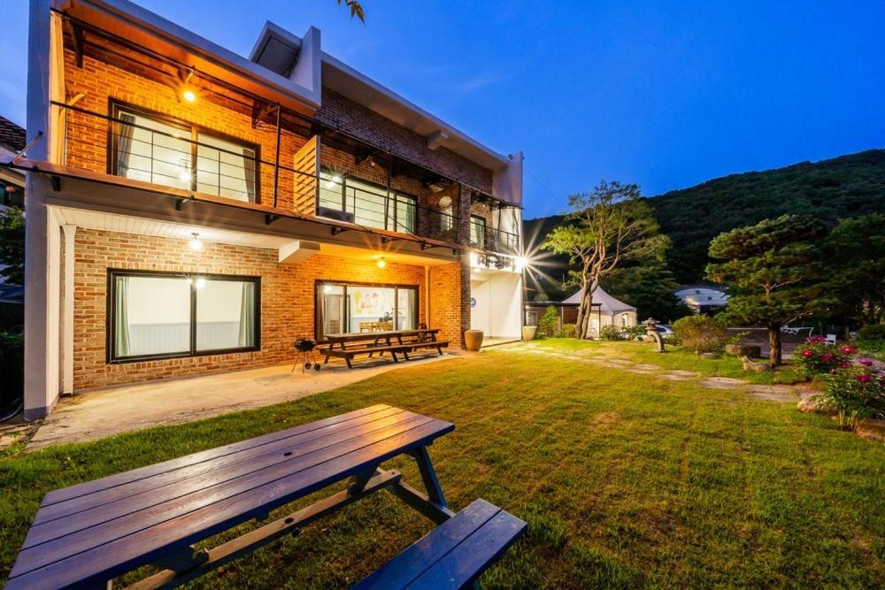 a wooden bench sitting in the yard of a house at Ganghwa Bridge House in Incheon