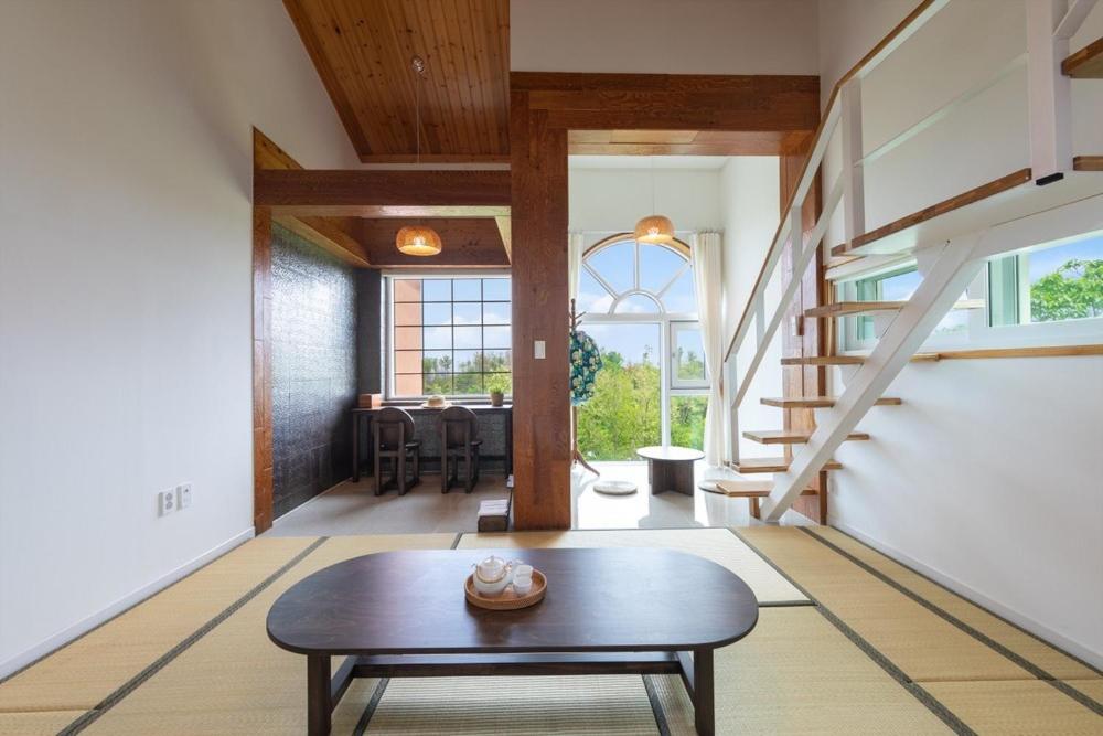 ein Wohnzimmer mit Tisch und ein Esszimmer in der Unterkunft Gangneung Mirabell Spa Pension in Kyŏngp'o-mal