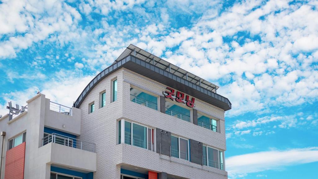 a hotel building with a blue sky and clouds at Samcheok Jangho Good Morning Pension in Yonghwa