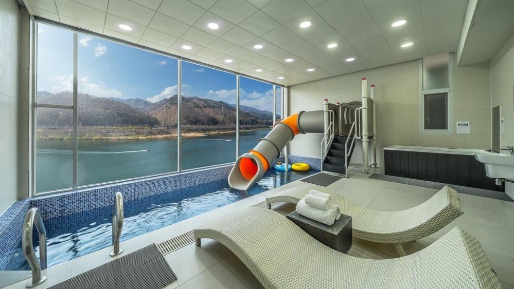a bathroom with a large window with a water slide at Gapyeong River Wave Pool Villa in Gapyeong