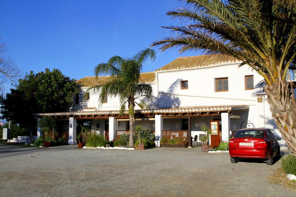 a red car parked in front of a white building at Hotel Mas Prades in Deltebre