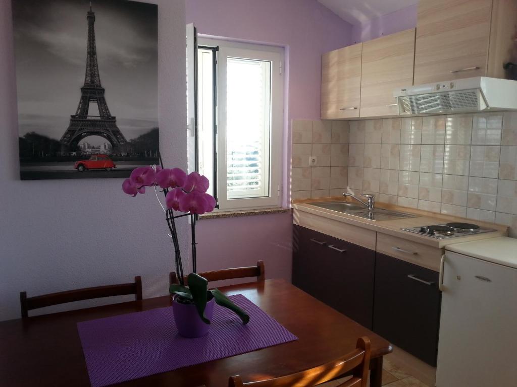 a kitchen with a vase with a flower on a table at Apartments Roncevic in Zadar