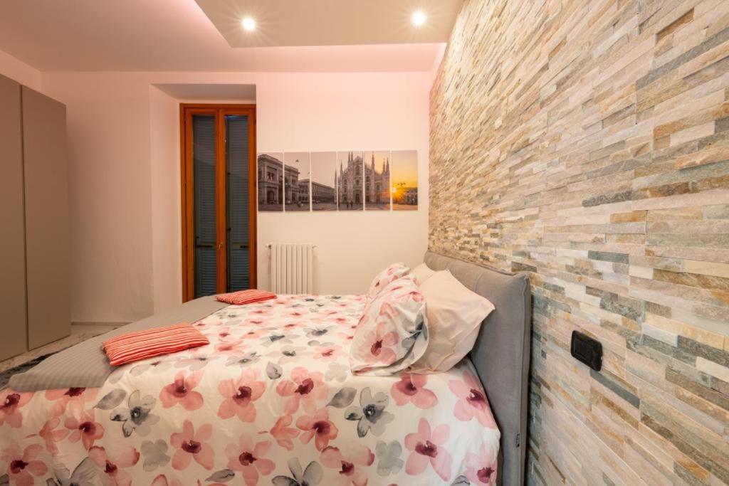 ein Schlafzimmer mit einem Bett und einer Ziegelwand in der Unterkunft Villa&Colombo in Rho