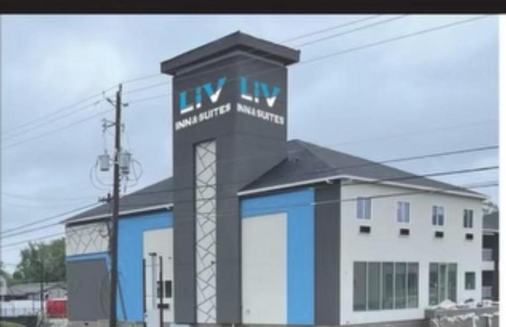 a building with a sign on top of it at LiV Inn & Suites Houston in Houston