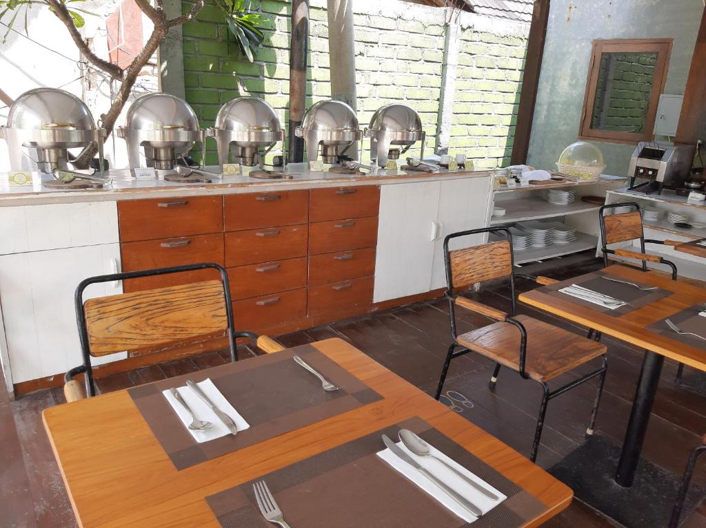 a kitchen with tables and chairs in a restaurant at Mola2 Resort Gili Air in Gili Islands