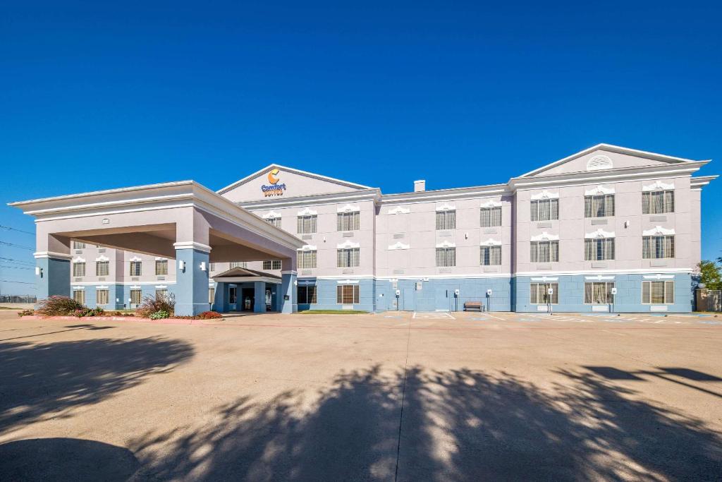 a large white building with a large driveway at Comfort Suites Roanoke - Fort Worth North in Roanoke