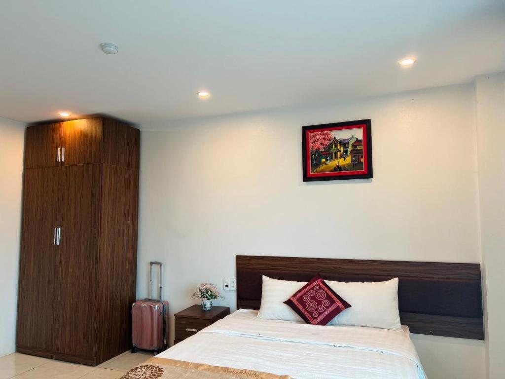 a bedroom with a bed and a picture on the wall at Mạnh Quỳnh Hotel in Tinh Xa