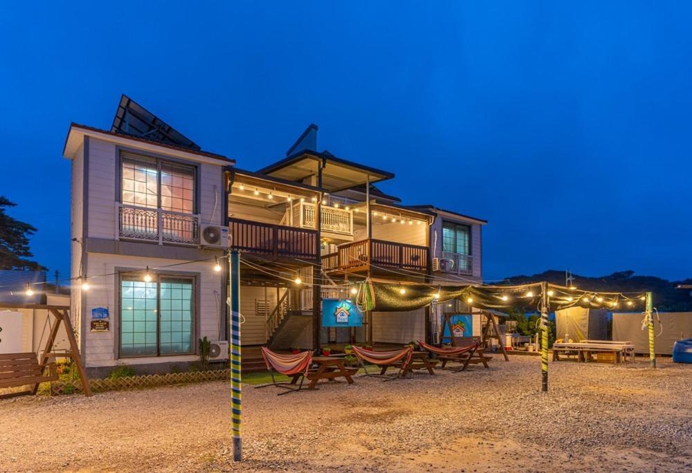 ein Haus mit Stühlen und Tischen davor in der Unterkunft Family Couple Pension Harupia in Taean