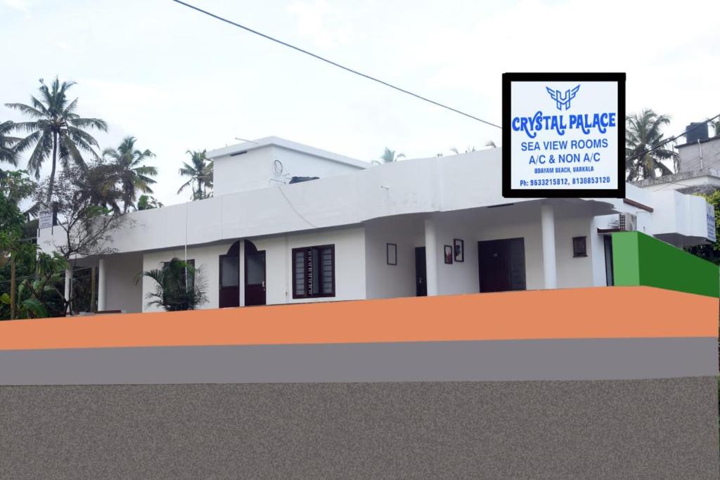 a white house with a sign in front of it at Crystal Palace Odayam in Varkala