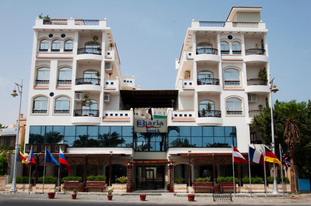 a large white building with flags in front of it at Elaria Hotel Hurgada in Hurghada