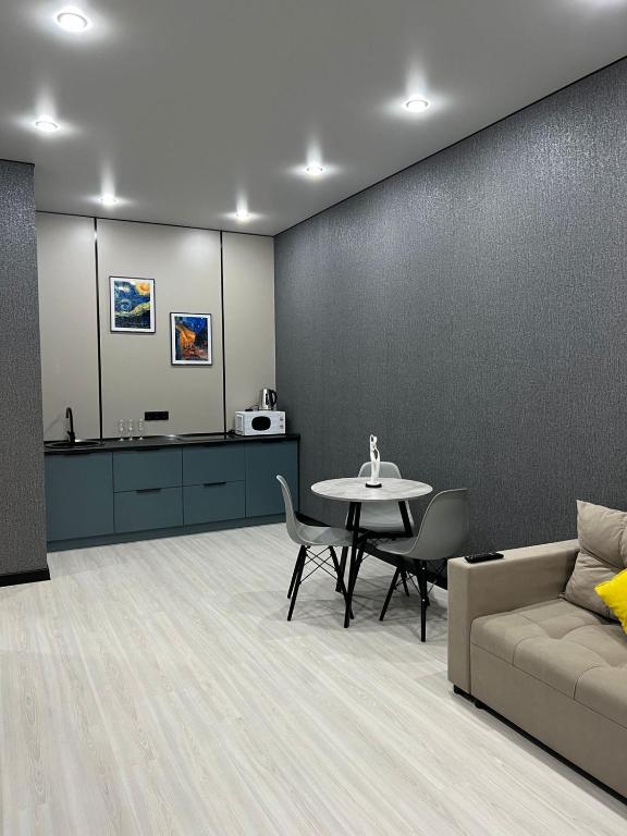 アスタナにあるСтильные апартаменты ЖК Тандауのテーブル、ソファ、テーブル、椅子が備わる客室です。