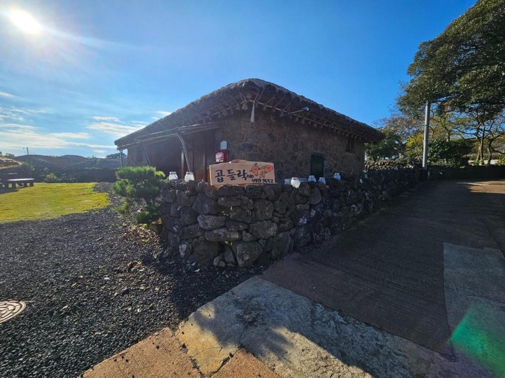 a stone wall in front of a building at Jeju Gopdeulak in Seogwipo