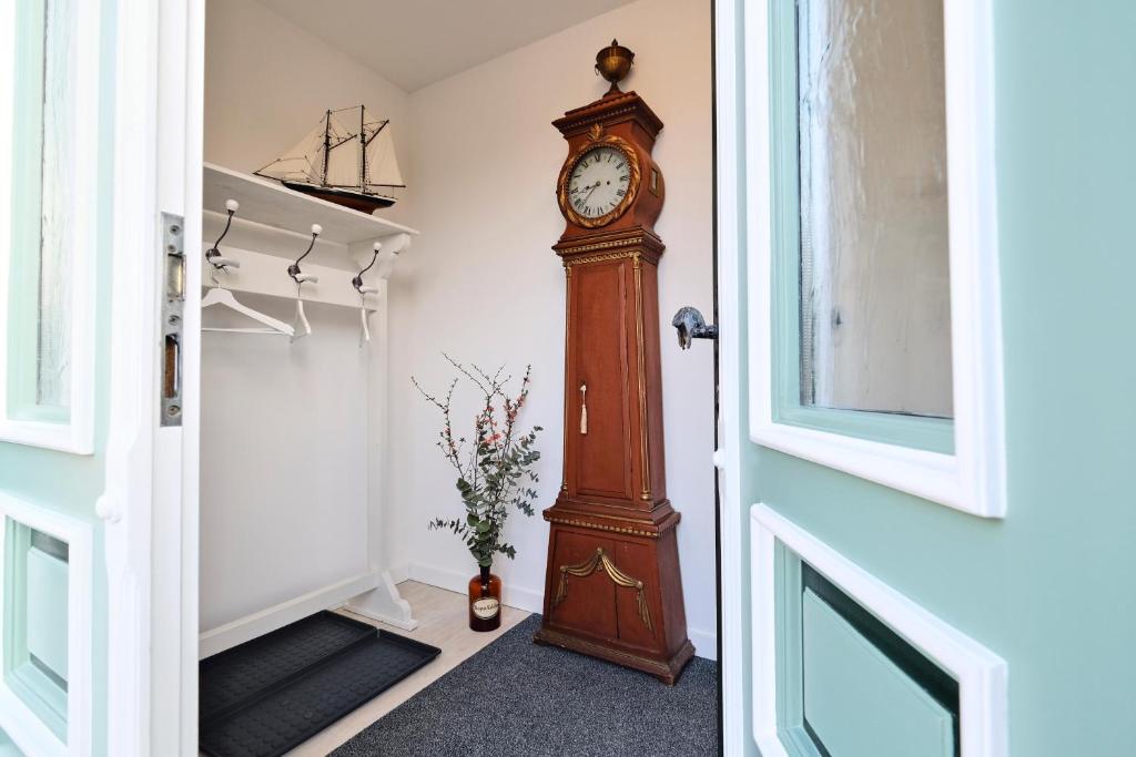 un reloj de abuelo en la esquina de una habitación en De lütte Boben, en Dollerup