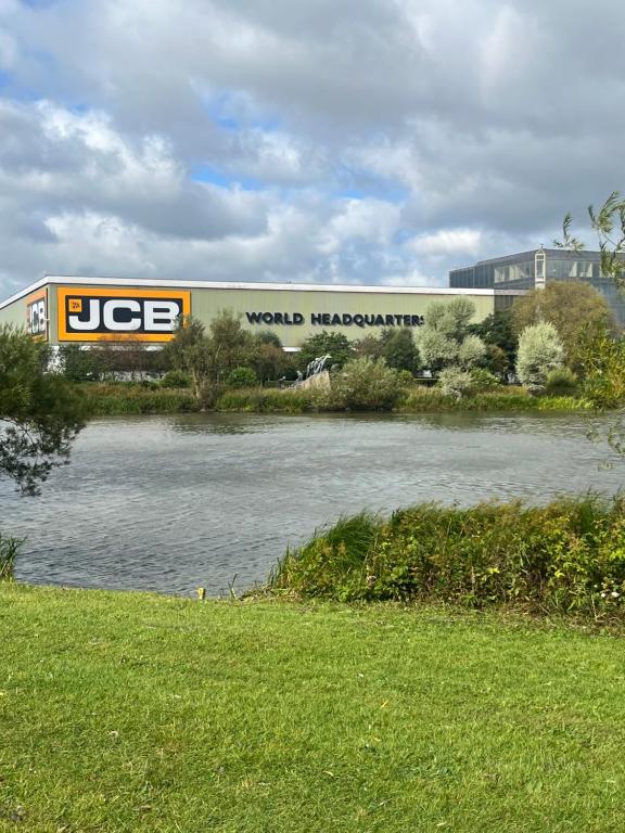 ein großes Gebäude neben einem Gewässer in der Unterkunft Gladstone cottage in Rocester