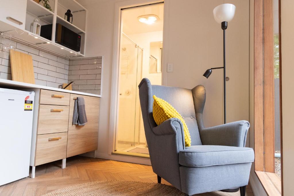 a living room with a chair and a kitchen at Cosy and Pet Friendly Blackheath Studio 2 in Blackheath