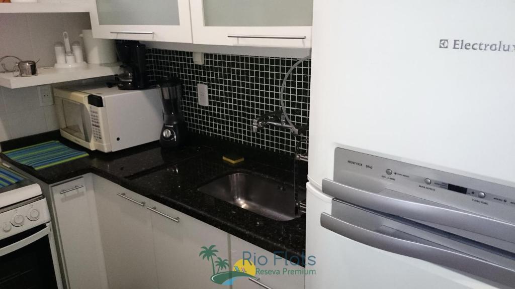 a kitchen with a sink and a microwave at Apart Hotel Leblon Ocean in Rio de Janeiro