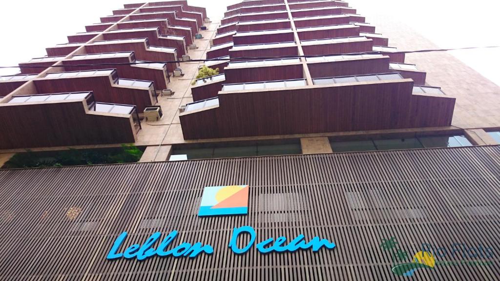 a tall building with a sign in front of it at Apart Hotel Leblon Ocean in Rio de Janeiro