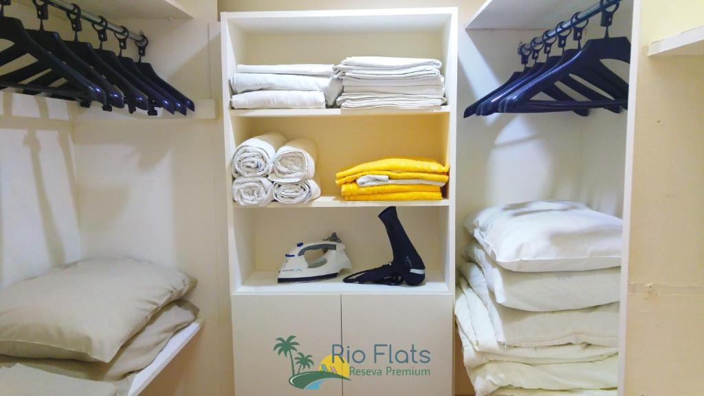 a closet with white shelves and towels at Apart Hotel Leblon Ocean in Rio de Janeiro