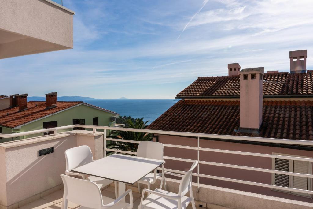 a patio with a table and chairs on a balcony at Casa M Rabac in Rabac