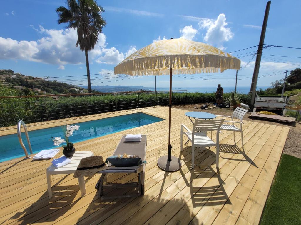 un patio avec une table, des chaises et un parasol dans l'établissement Villa Neuve avec magnifique vue Mer, à Mandelieu-la-Napoule