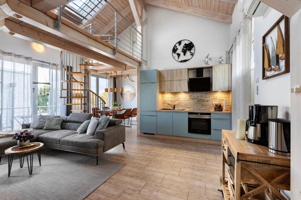 a living room with a couch and a kitchen at Fewo Seeschwalbe - Marina Mücheln in Mücheln