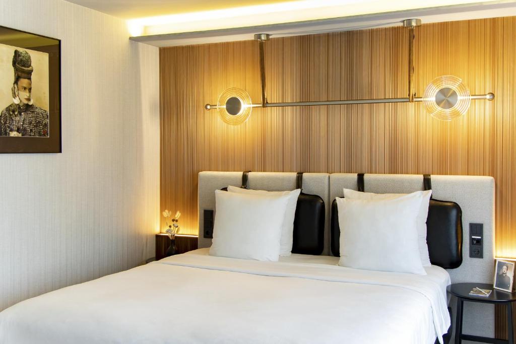 a bedroom with a large bed with white pillows at MUZE Hotel Dusseldorf - Handwritten Collection in Düsseldorf