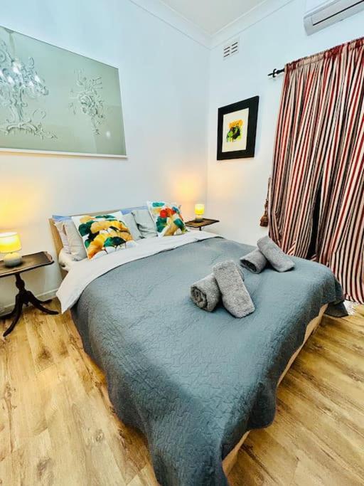 a bedroom with a bed with two pillows on it at XL Massive Art-Filled Home in Central Area, WALK to Sliema, St Julian's in Il-Gżira