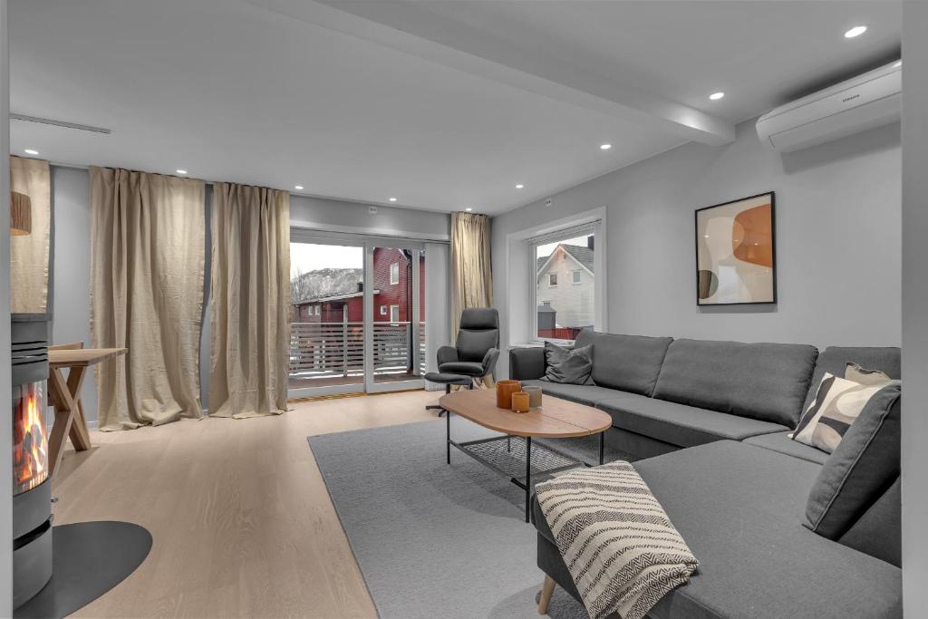 a living room with a couch and a table at Northstay - The Arctic Pearl, Central House with 4 bedrooms and 2 bathrooms in Tromsø