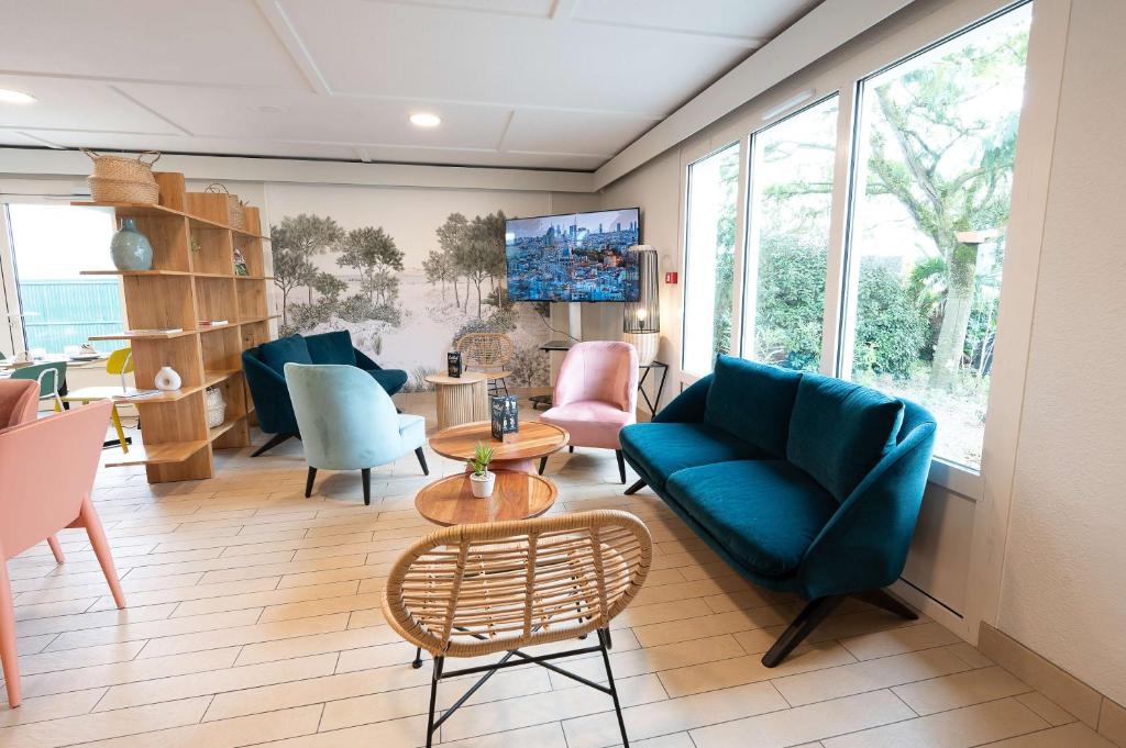 a living room with a blue couch and chairs at Sure Hotel by Best Western Rochefort-sur-Mer in Tonnay-Charente