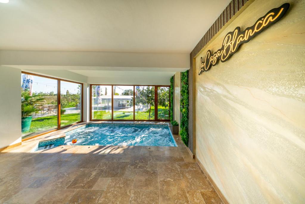 een zwembad in een gebouw met een bord aan de muur bij La Casa Blanca in Vladimirescu