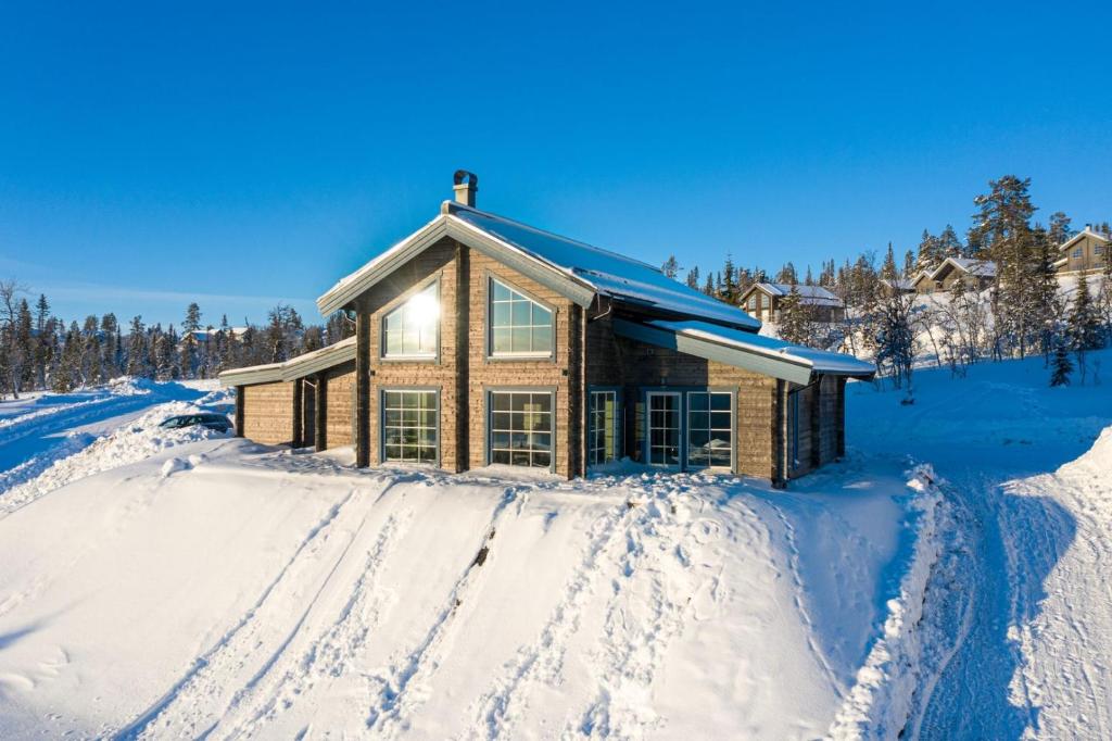 a house in the snow with tracks in the snow at Ski-in/Ski-out | Sauna | WiFi | Free EV-charger in Lofsdalen