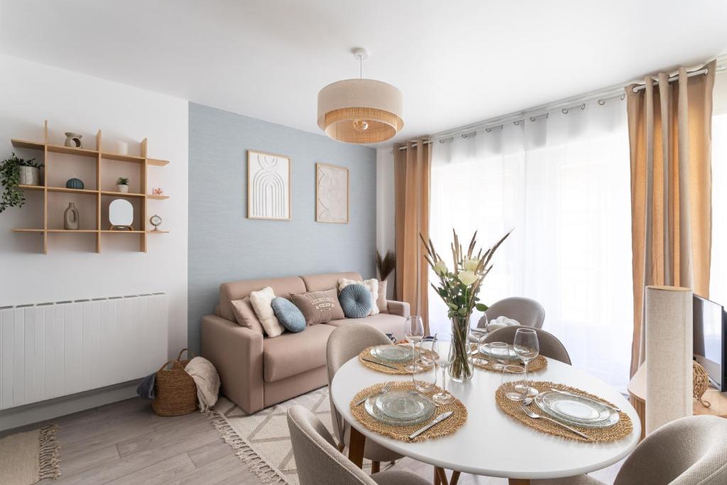 un salon avec une table et un canapé dans l'établissement Malouine - A 450m de la plage avec garage privatif, à Saint-Malo