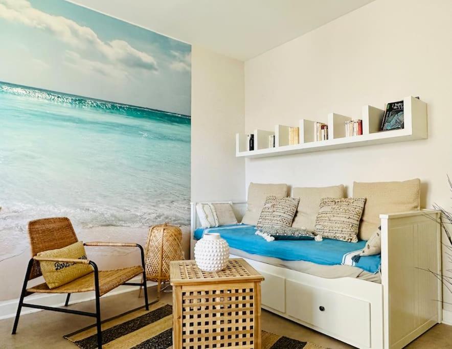 une chambre avec un lit et une vue sur l'océan dans l'établissement charmant T2 50m plage de Pontaillac, à Royan