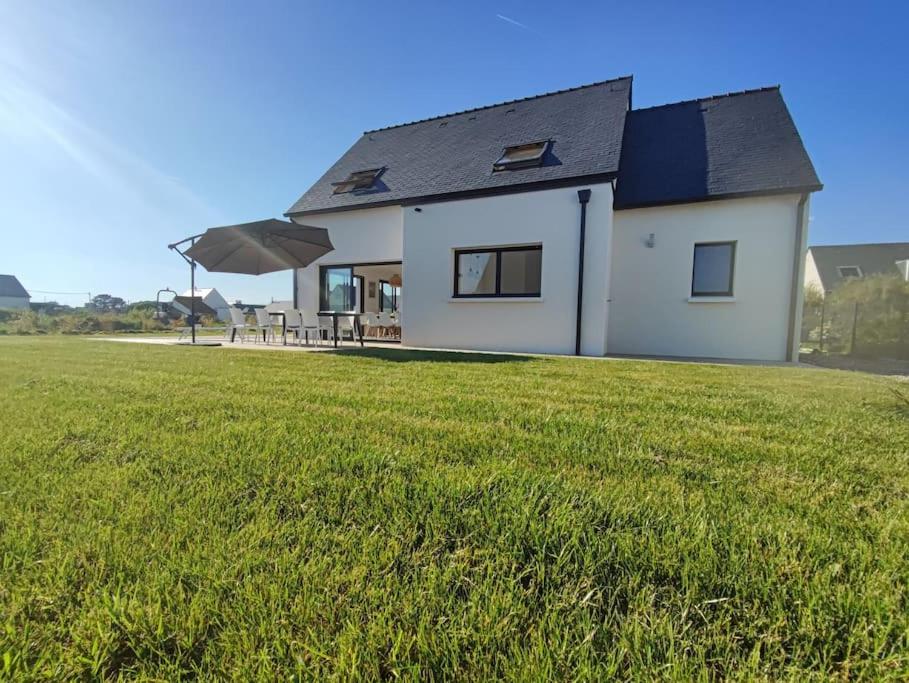 une maison blanche avec une grande pelouse dans l'établissement Grande maison neuve classée 4 étoiles à 300m de la mer, à Plobannalec-Lesconil