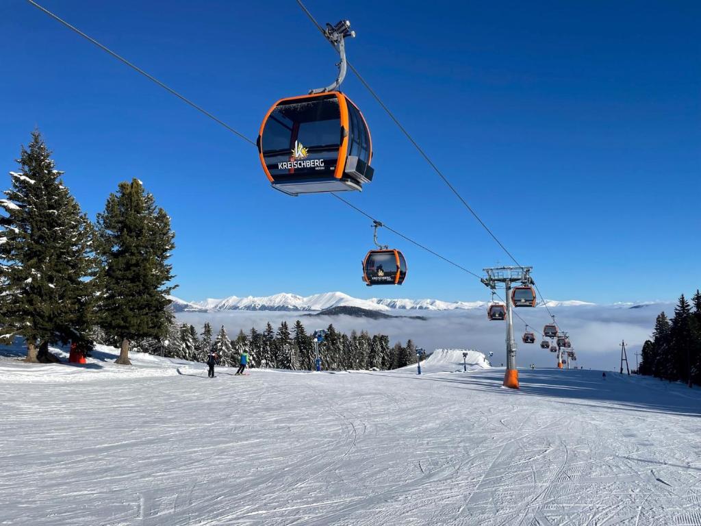 un remonte que sube a una pista de esquí cubierta de nieve en Appartement Cseho, en Murau