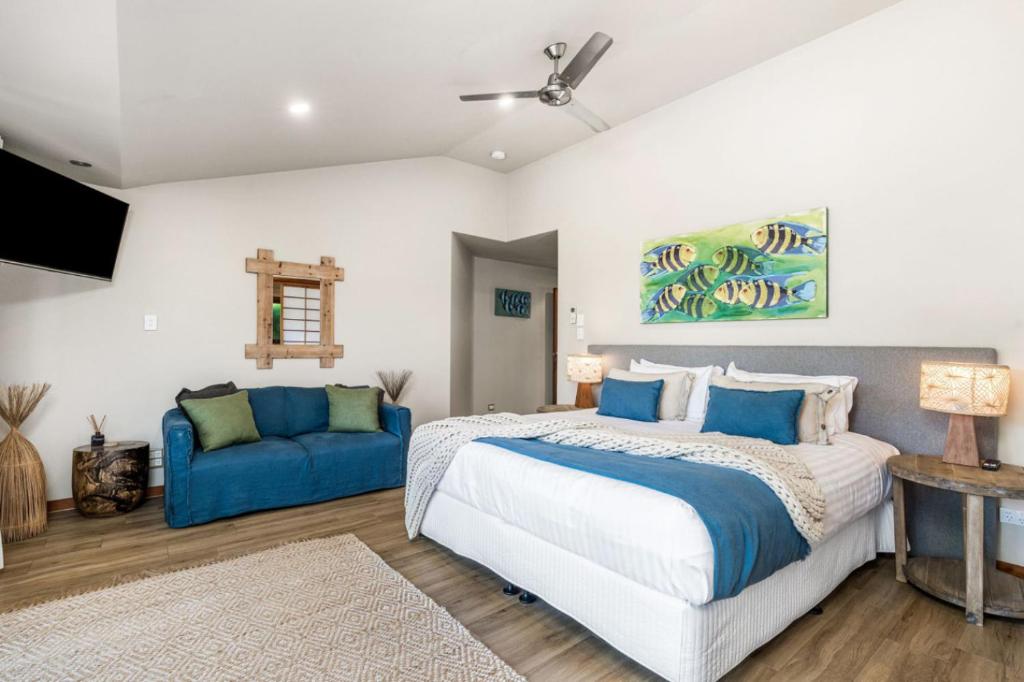 a bedroom with a bed and a blue couch at Cape Byron Suite 5 Private Suite with Ensuite in Byron Bay