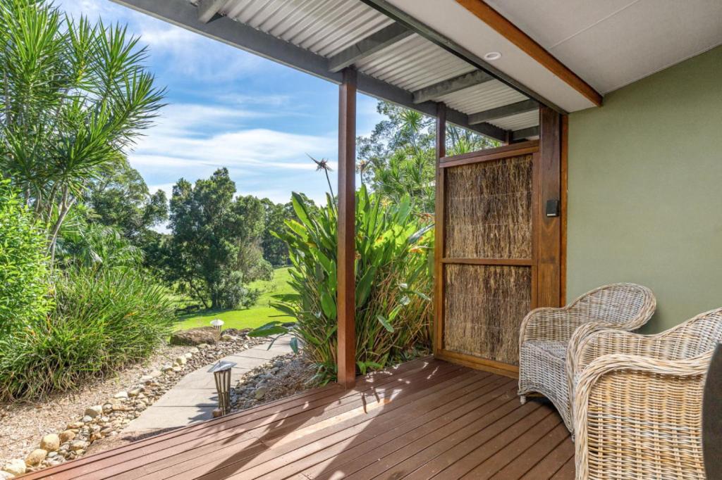 a patio with two wicker chairs on a wooden deck at Cape Byron Suite 5 Private Suite with Ensuite in Byron Bay