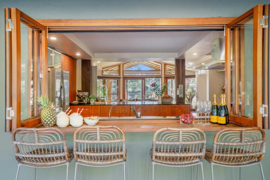 a kitchen with a counter with chairs and a sink at Cape Byron Suite 5 Private Suite with Ensuite in Byron Bay