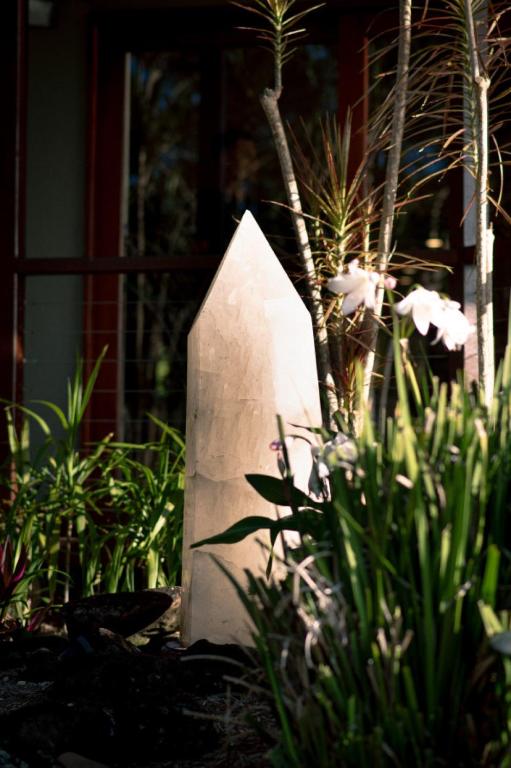 a stone pillar in a garden with plants at Cape Byron Suite 5 Private Suite with Ensuite in Byron Bay