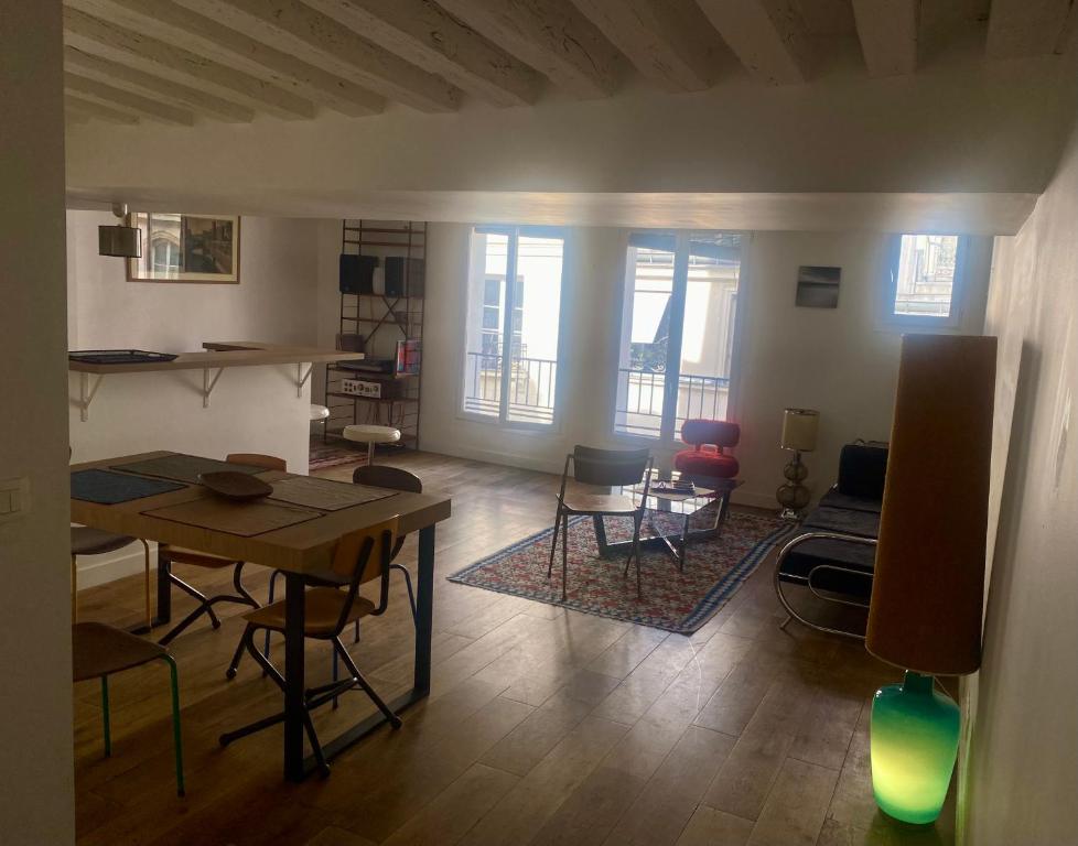 un salon avec une table et quelques chaises dans l'établissement ParisLouvreSamaritaineCharme, à Paris