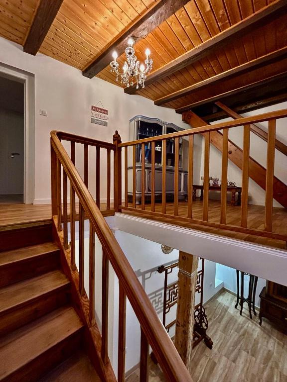 - un escalier en bois dans une maison dotée d'un lustre dans l'établissement Charmante maison de 140m2 au bord de la rivière au coeur de Wissembourg, à Wissembourg