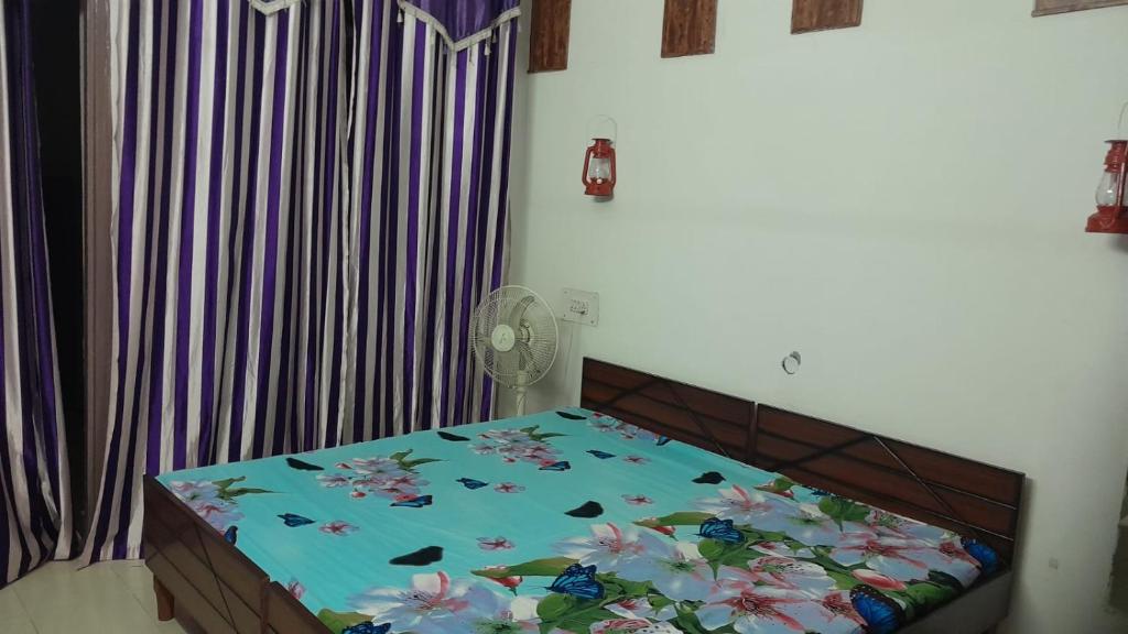 a bedroom with a bed with flowers on it at Holy Hills Homestay in Zirakpur