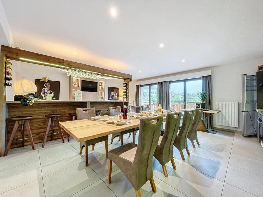 a dining room with a long wooden table and chairs at Les Trois Chaufatons - Chalets Boutiques in Montriond